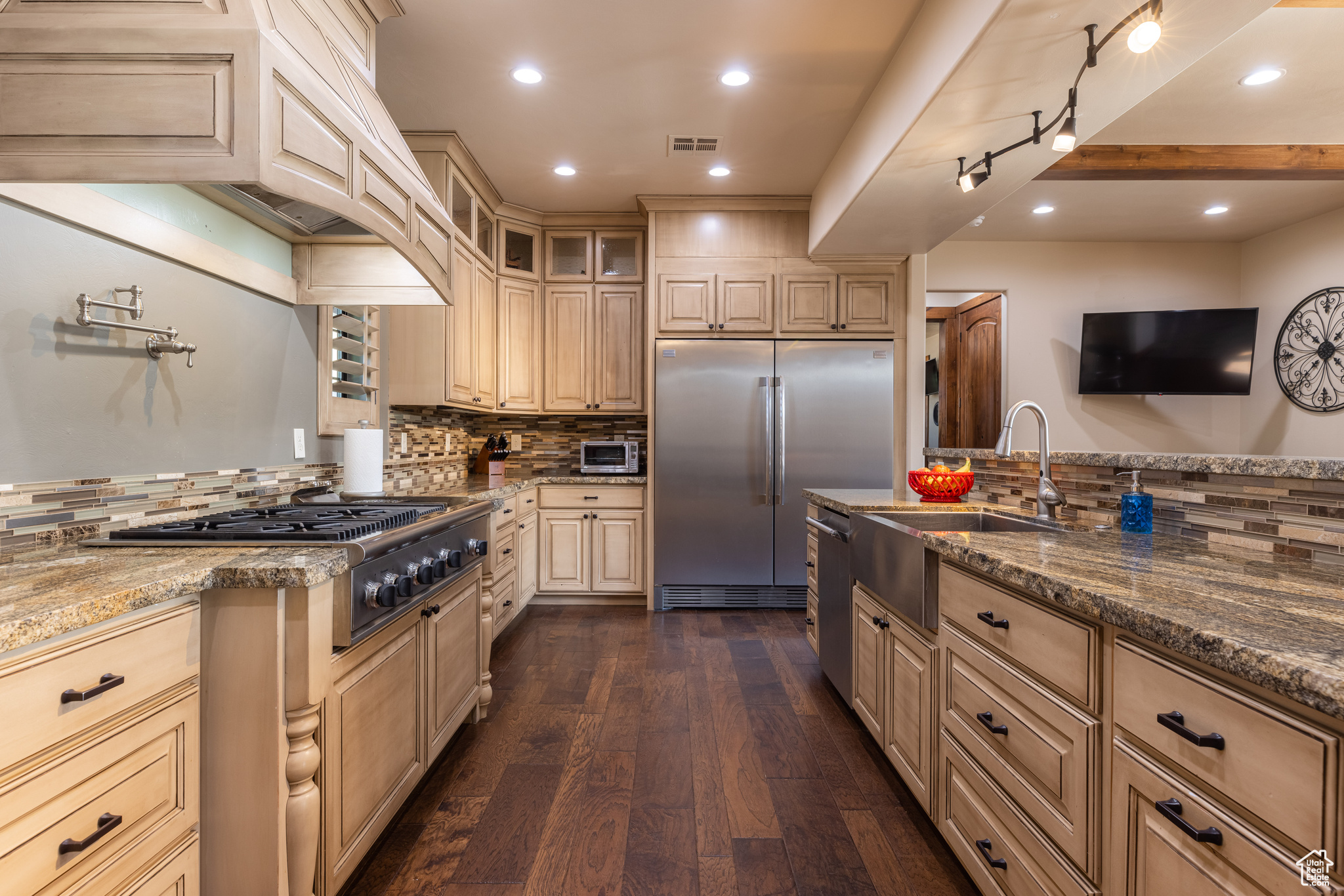 Kitchen featuring sink, tasteful backsplash, stainless steel appliances, dark hardwood / wood-style floors, and stone counters