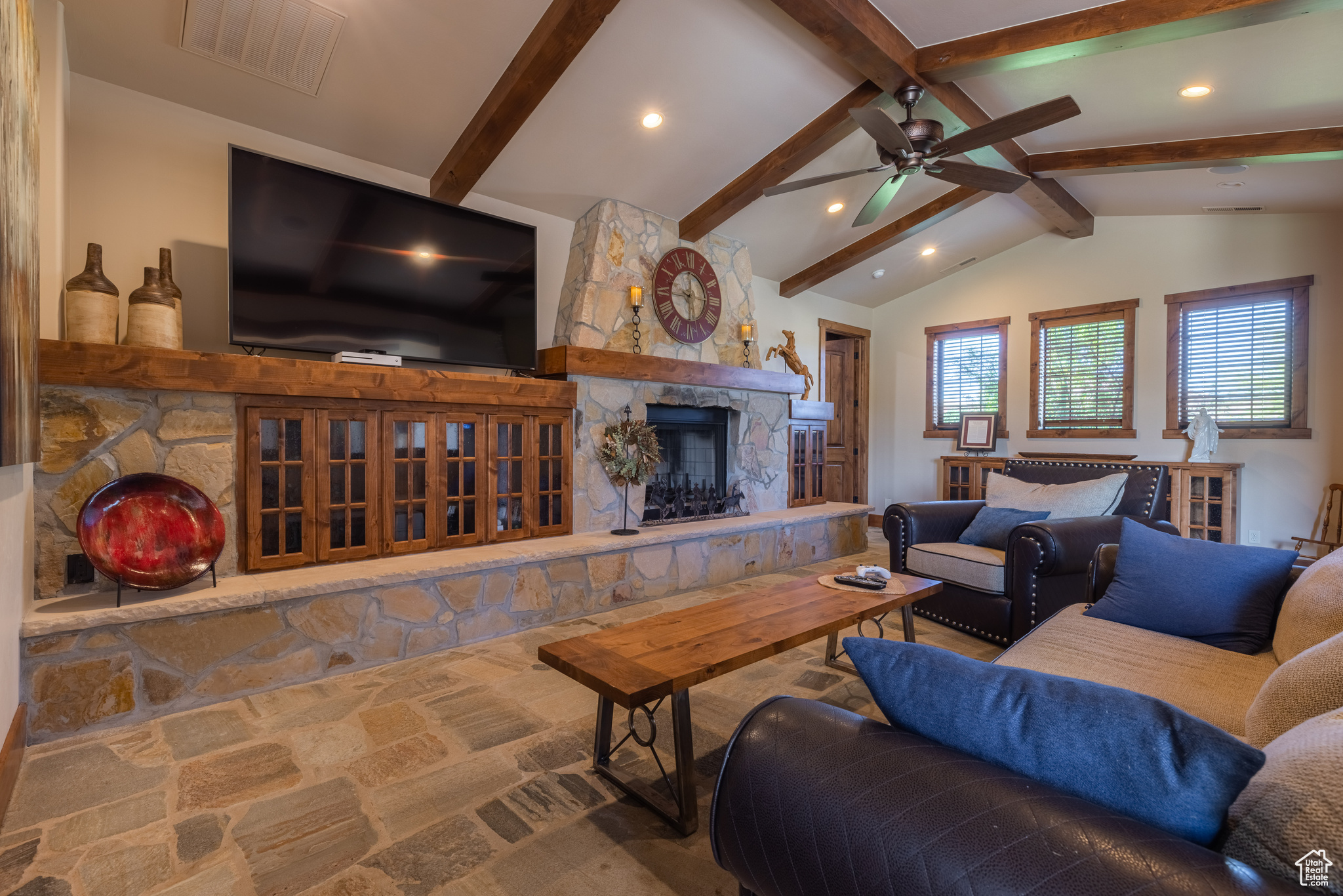 Great room with the Nevada slate flooring, lots of custom built-ins, ceiling fan, a fireplace, and lofted ceiling with beams