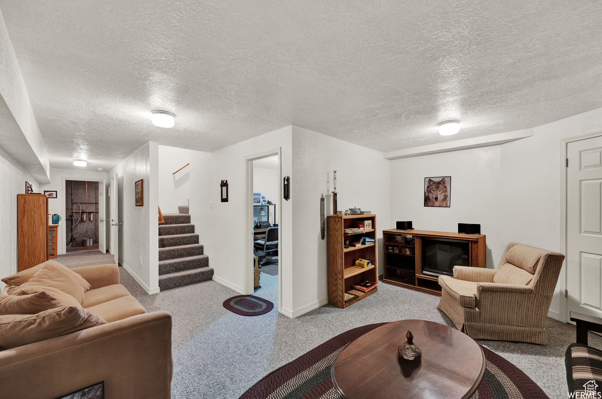 Carpeted living room with a textured ceiling