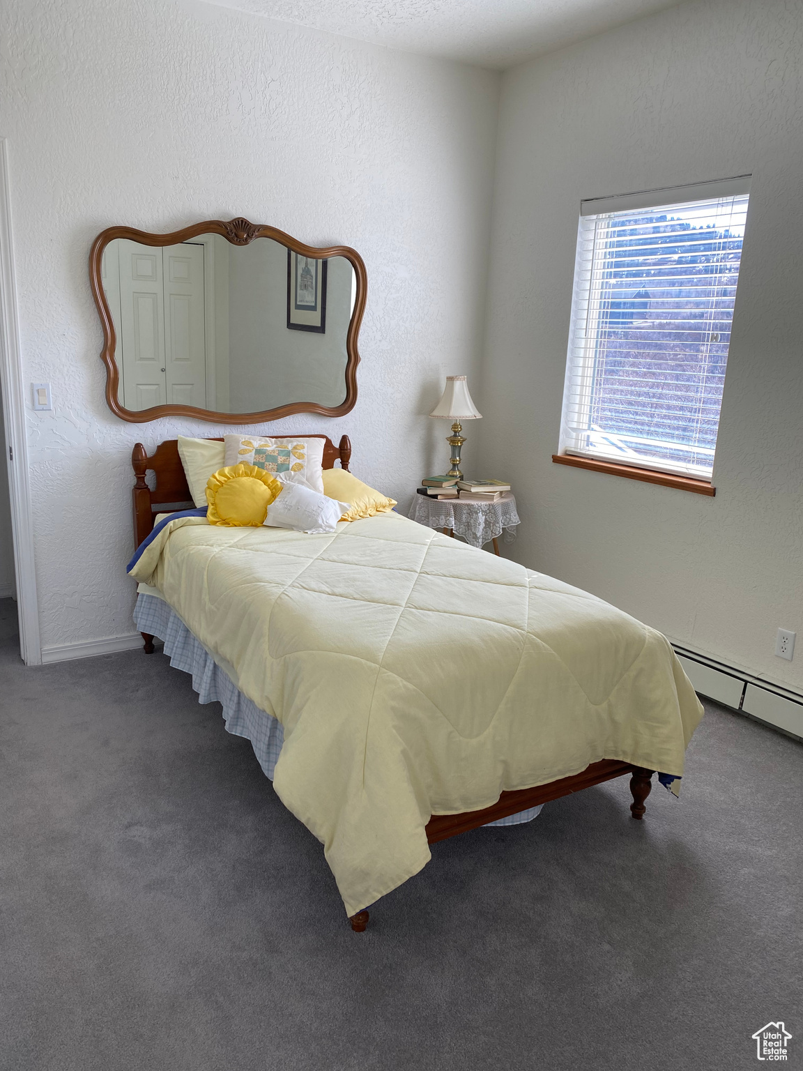 Carpeted bedroom featuring a baseboard heating unit