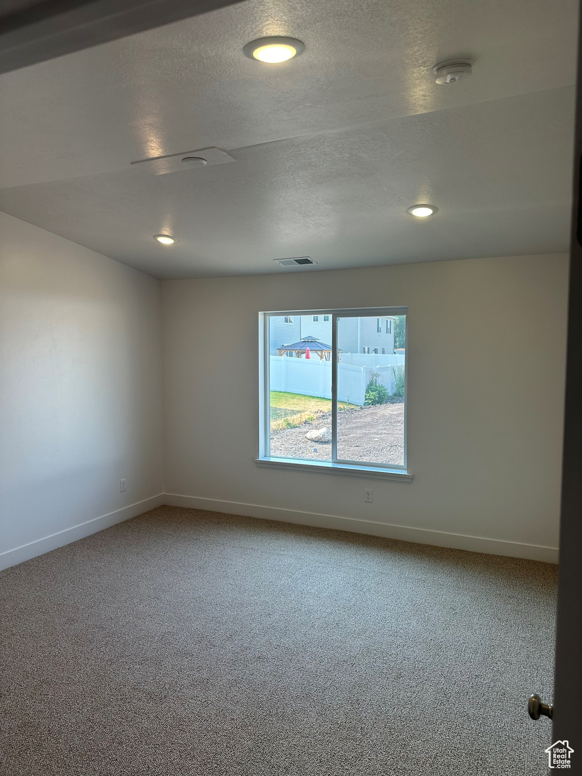 Unfurnished room with carpet flooring and a textured ceiling