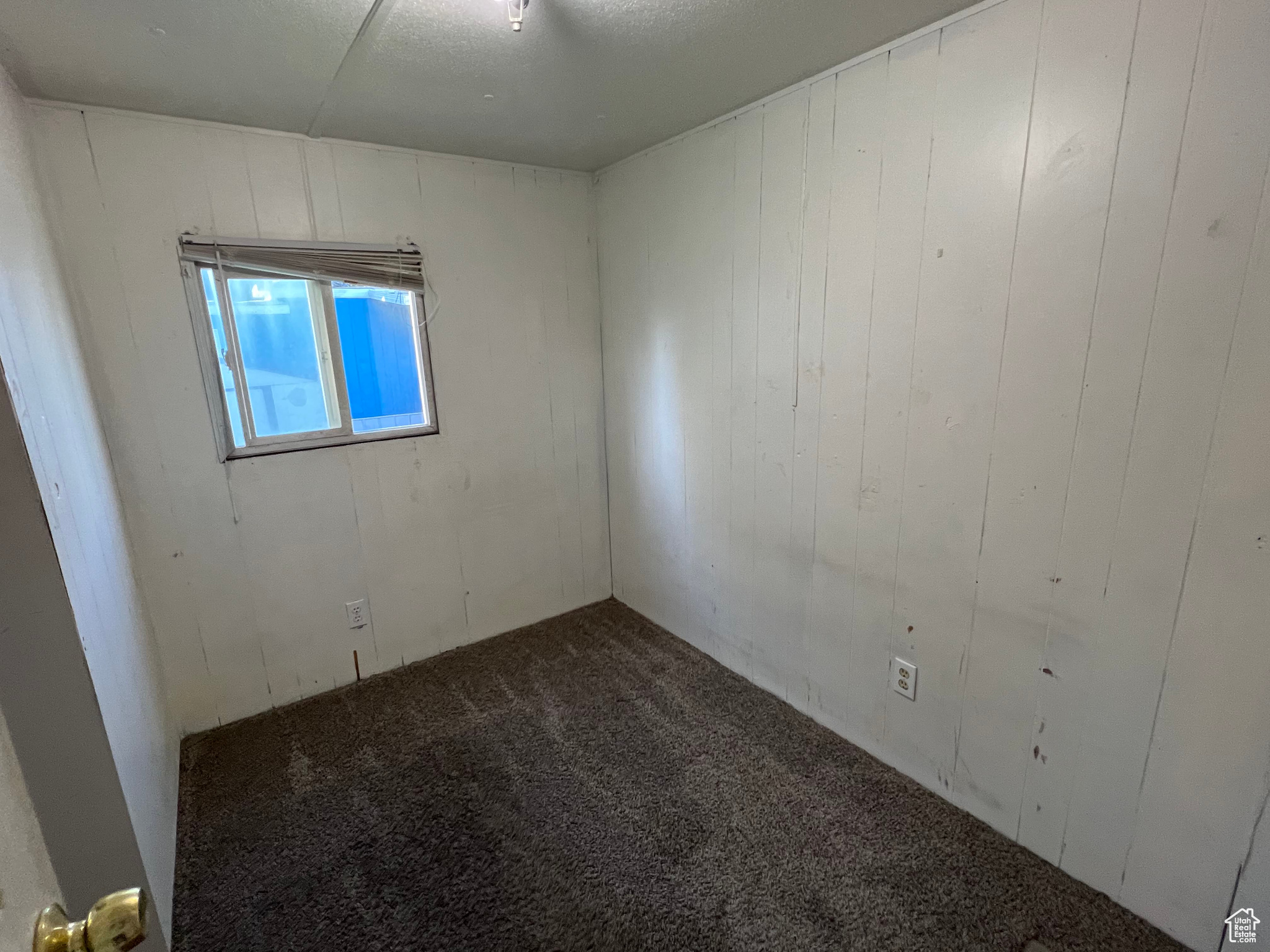 Carpeted empty room with a textured ceiling