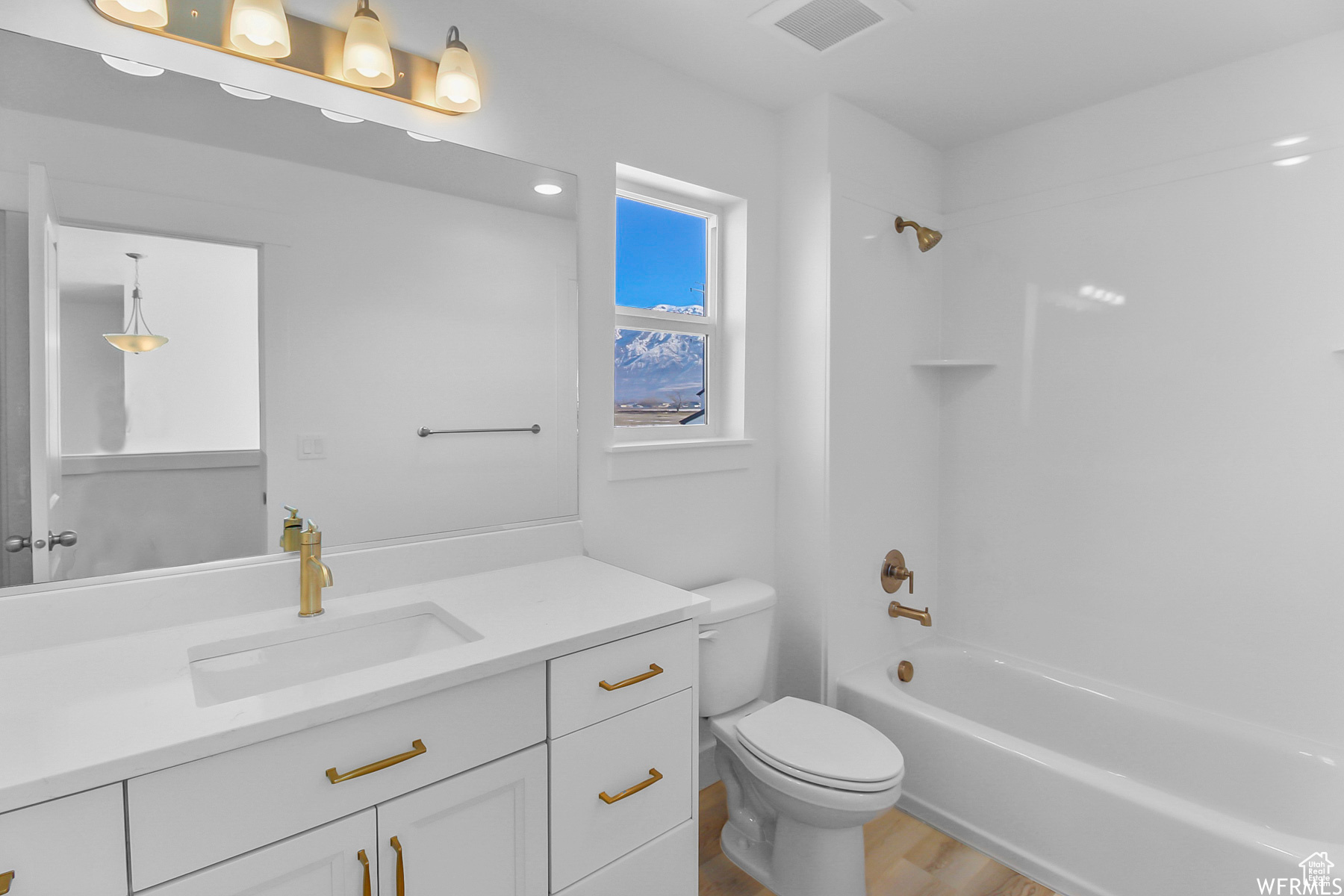 Full bathroom with shower / bath combination, hardwood / wood-style floors, toilet, and vanity