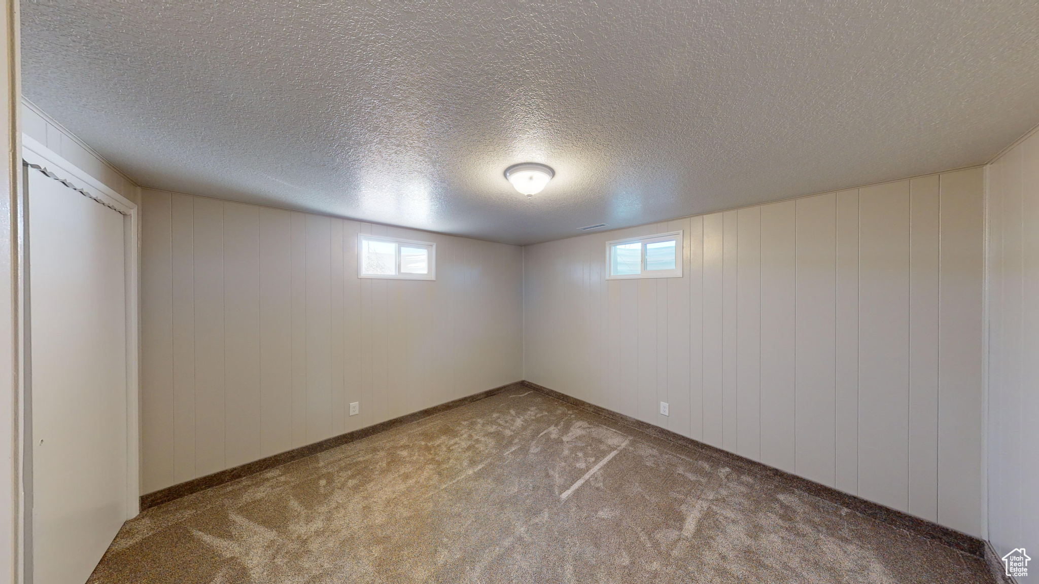 Basement featuring carpet flooring and a textured ceiling