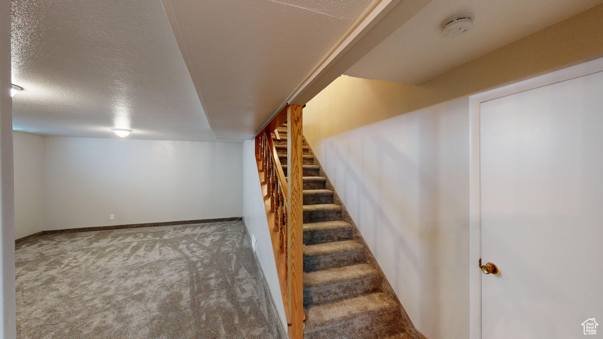 Staircase featuring carpet and a textured ceiling