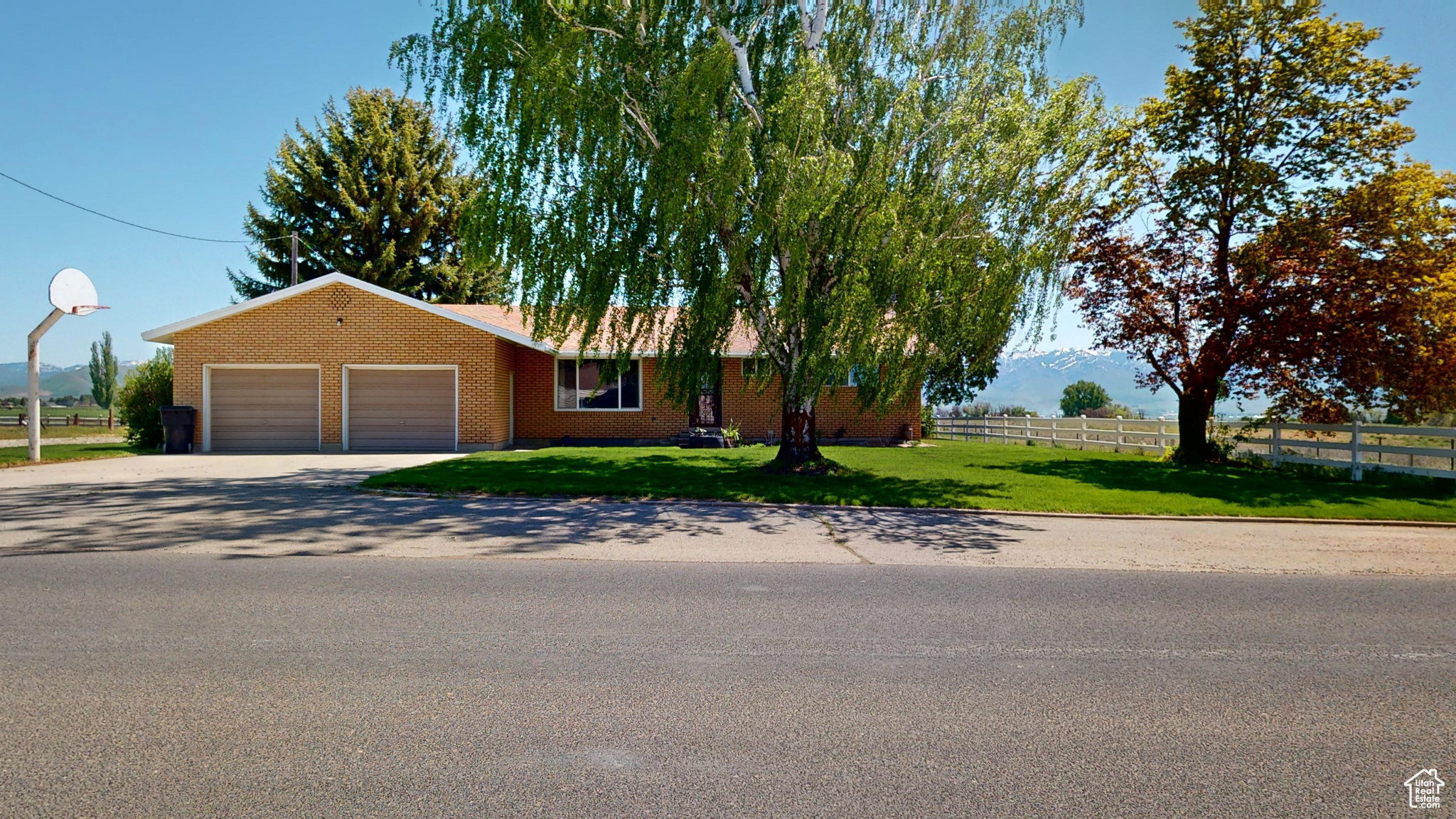 Ranch-style house featuring a garage and a front lawn