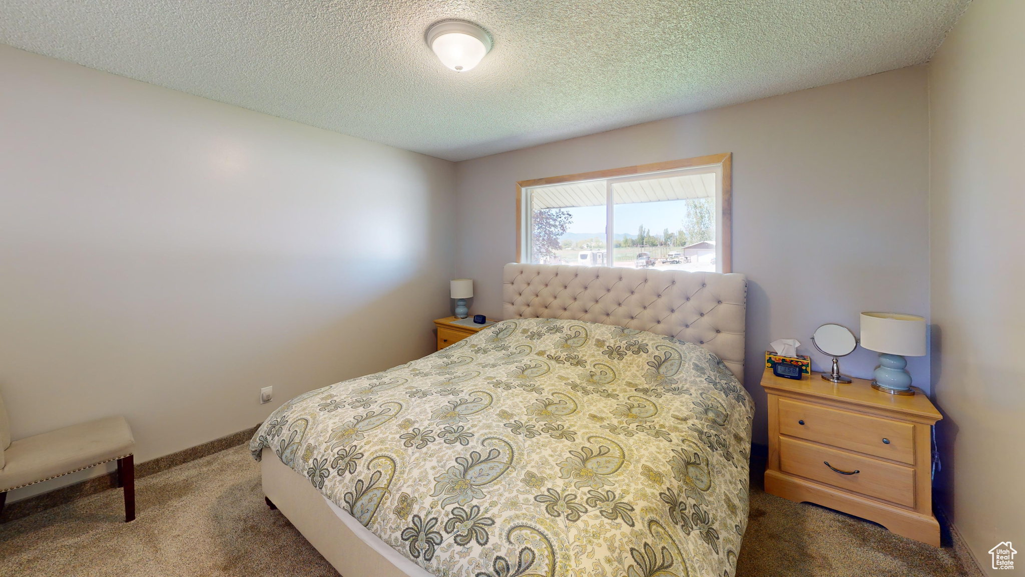 Bedroom with a textured ceiling and dark carpet