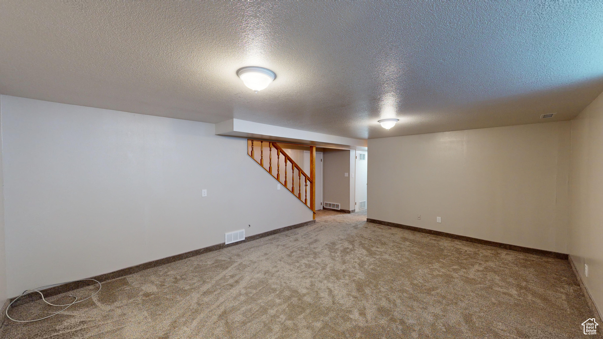 Basement featuring carpet floors and a textured ceiling