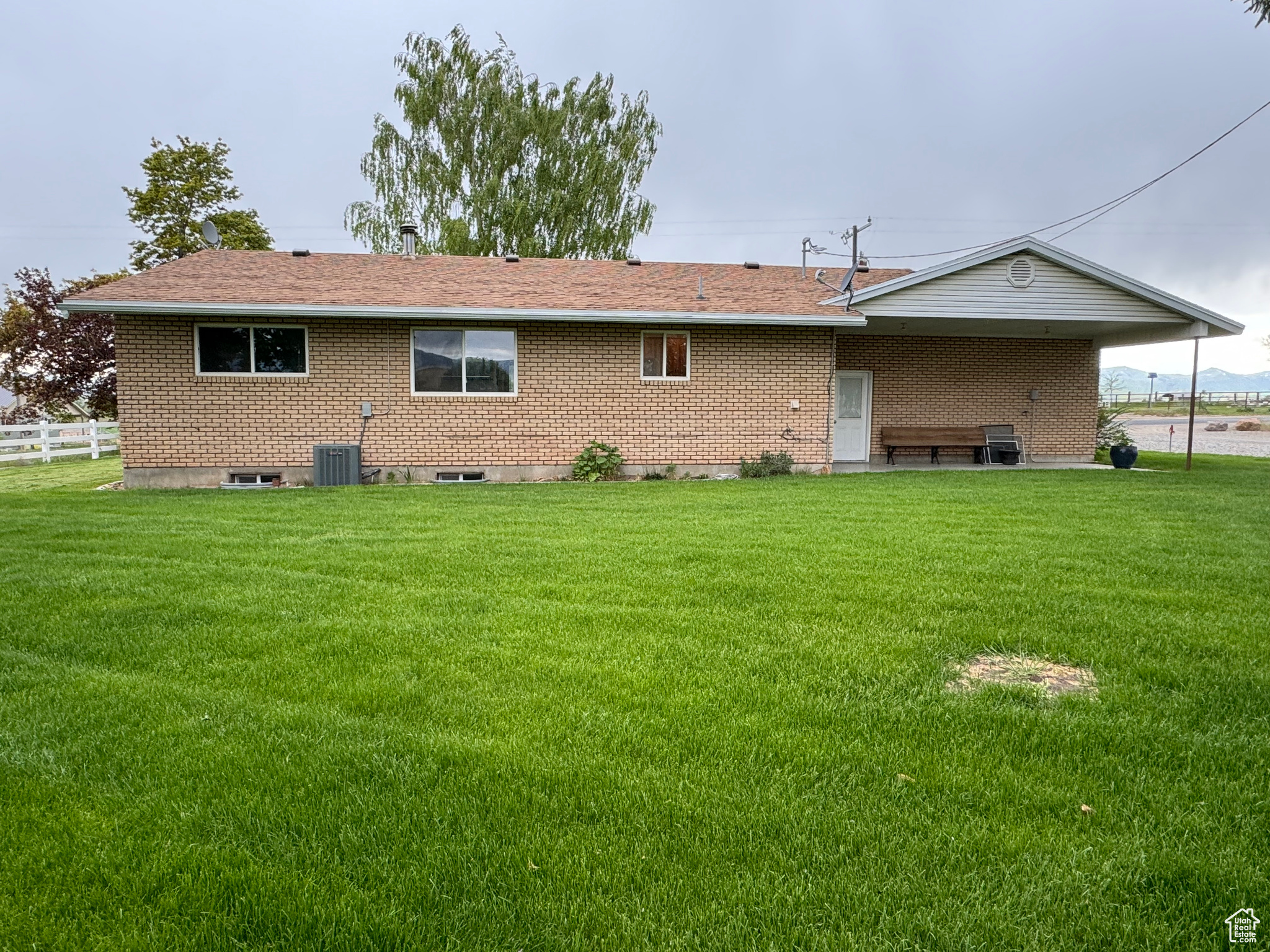 Back of house with a lawn and central air condition unit