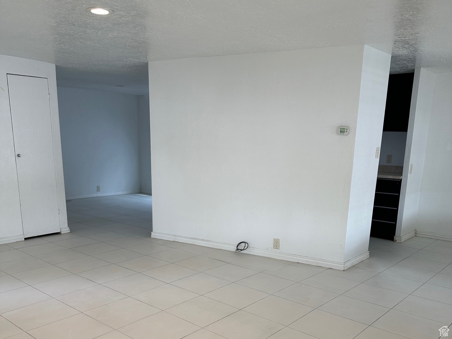 Tiled spare room with a textured ceiling