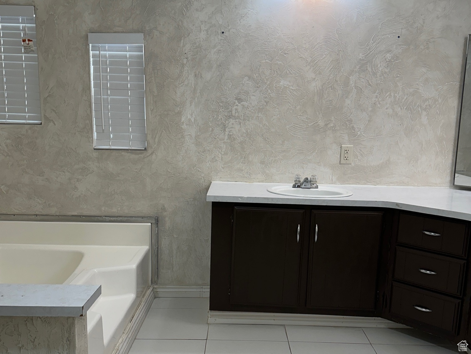 Bathroom with a tub, tile floors, and vanity