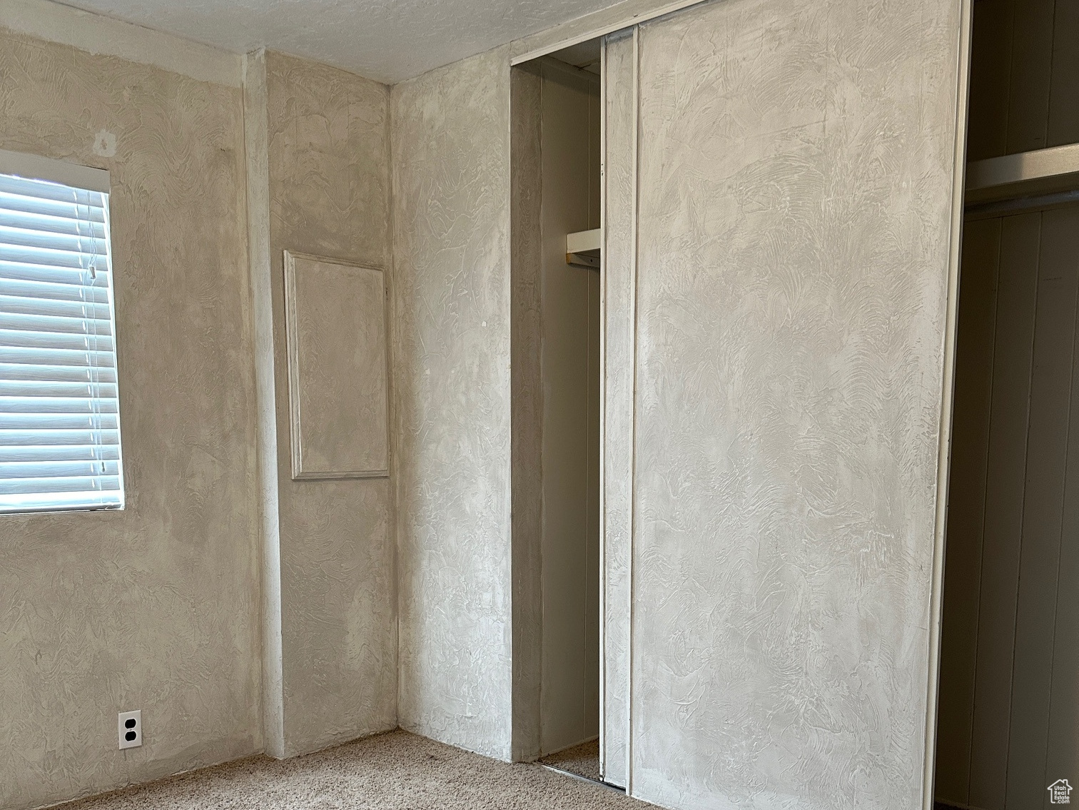 Unfurnished bedroom with a textured ceiling and carpet