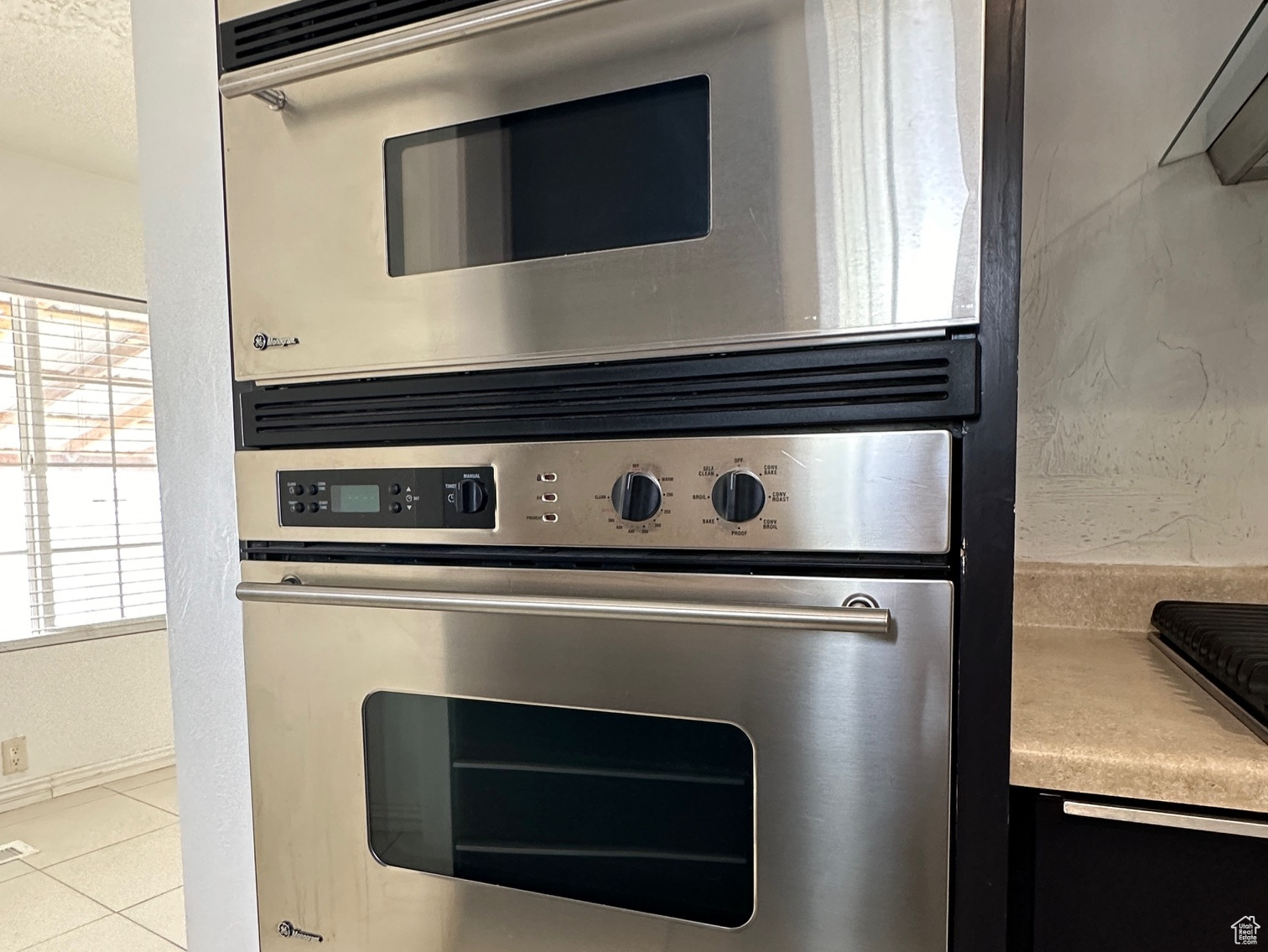 Kitchen featuring stainless steel double oven and light tile flooring