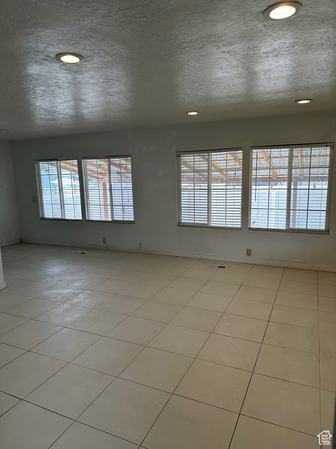 Tiled spare room with a textured ceiling