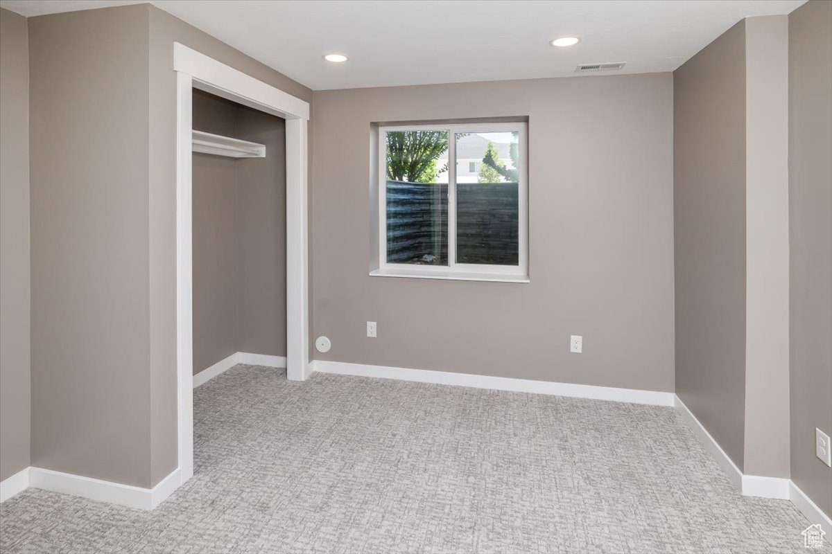 Unfurnished bedroom with a closet and light carpet