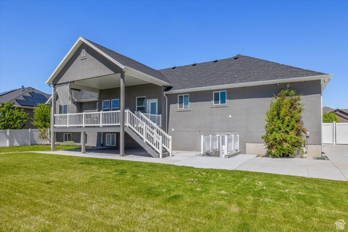 Back of house featuring a lawn and a patio area