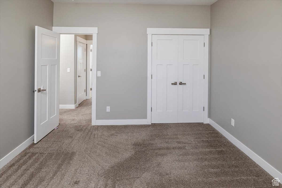 Unfurnished bedroom featuring a closet and carpet flooring