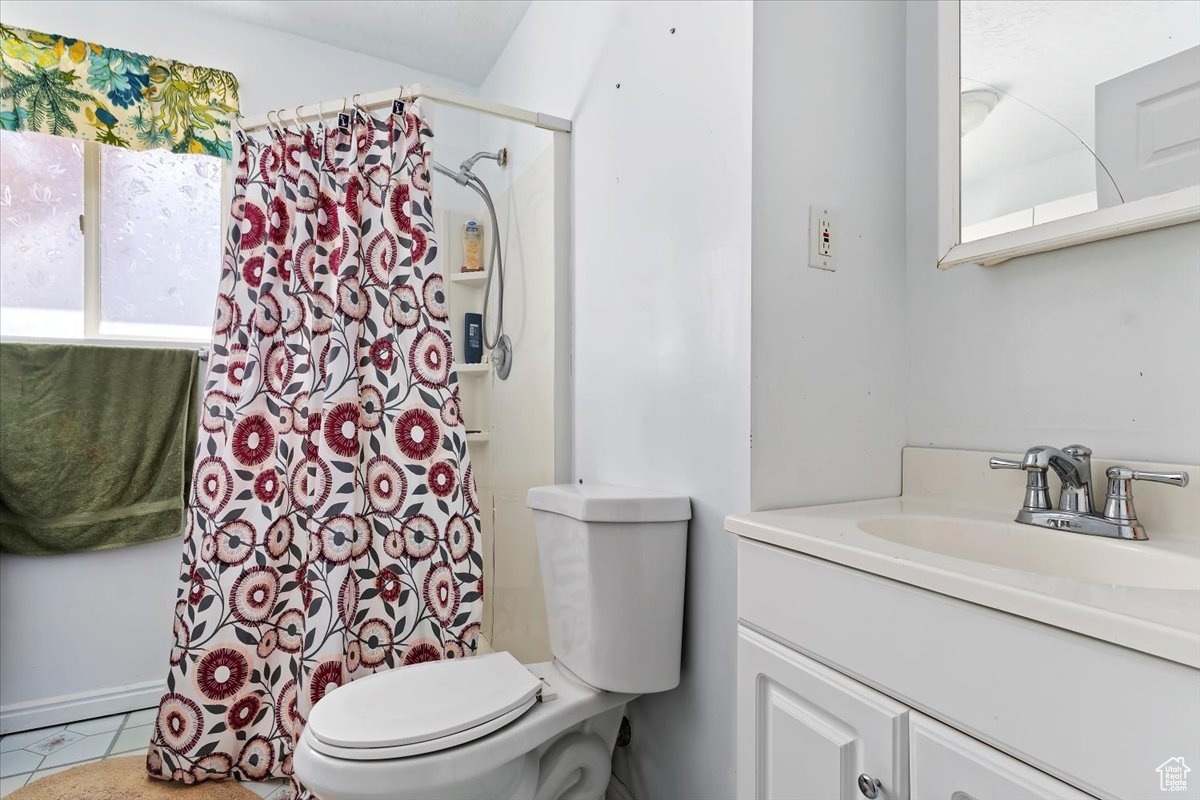Bathroom with tile floors, toilet, and large vanity