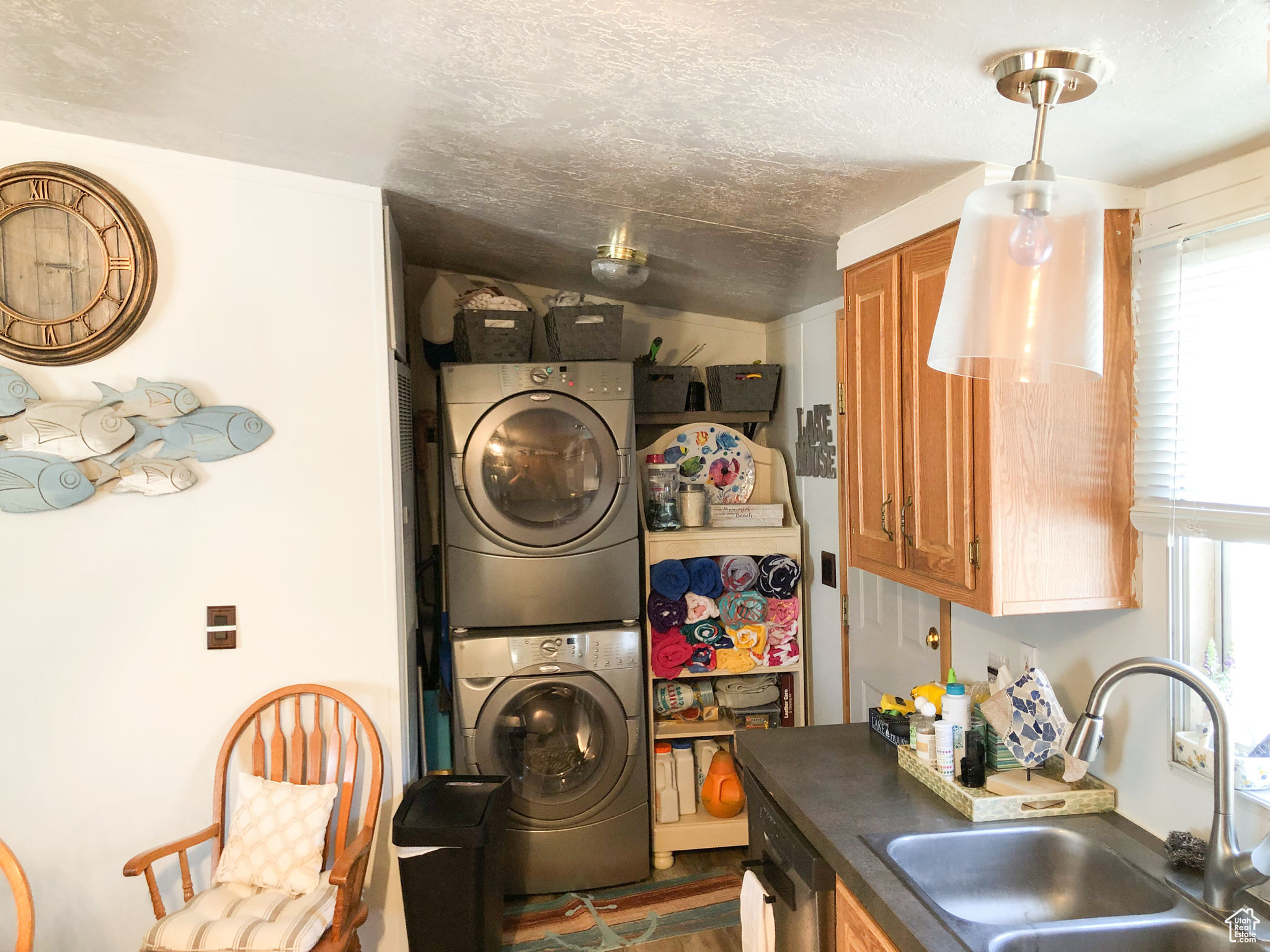 Stacked washing machine and dryer, kitchen sink, and a wealth of natural light