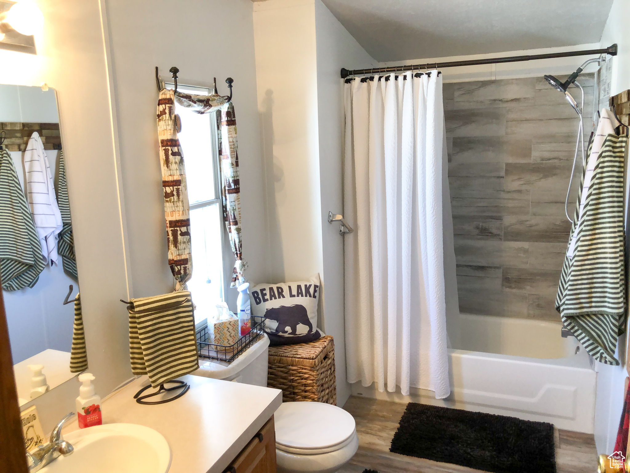 Primary bathroom featuring hardwood / wood-style flooring, vanity, toilet, and shower / tub combo