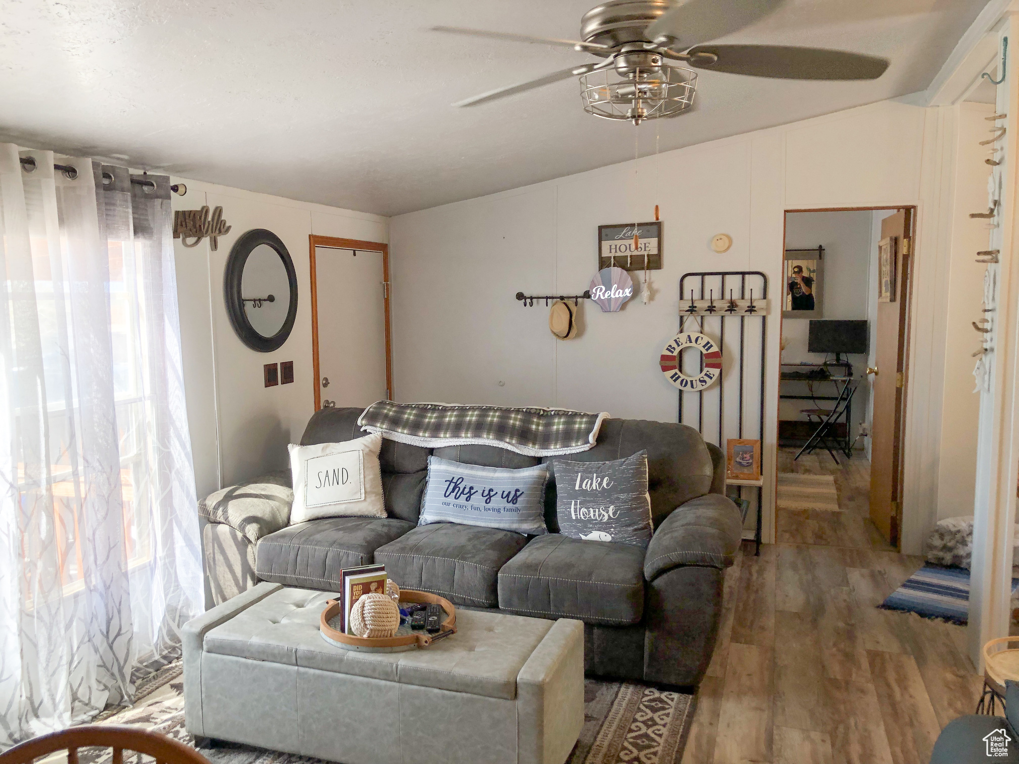 Living room with hardwood / wood-style flooring, ceiling fan, and lofted ceiling