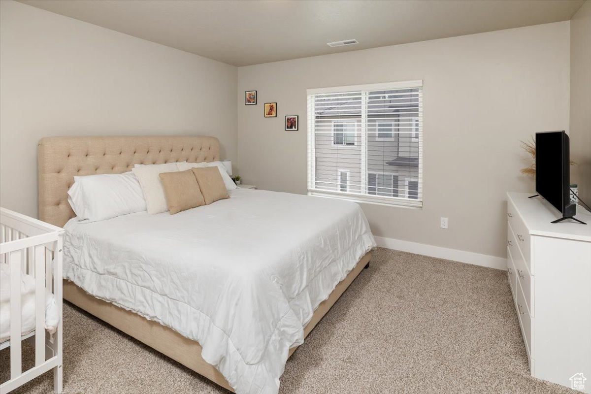 Bedroom featuring light carpet