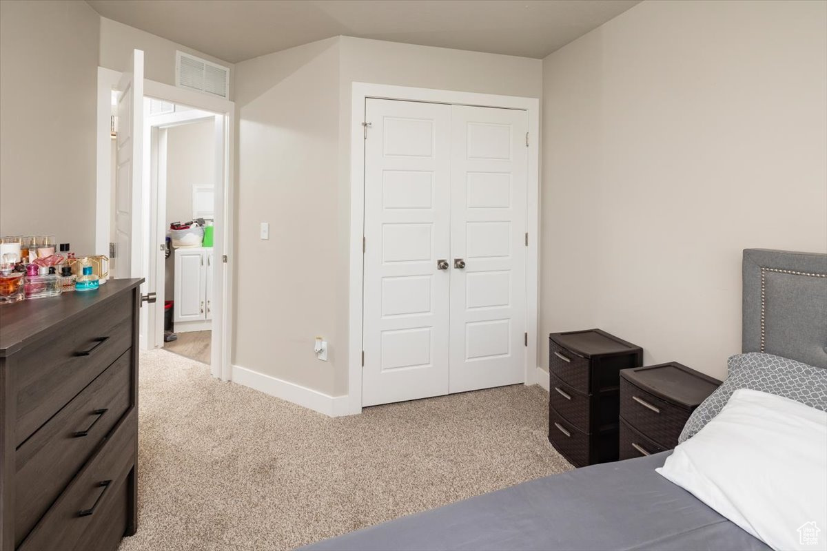 Carpeted bedroom with a closet