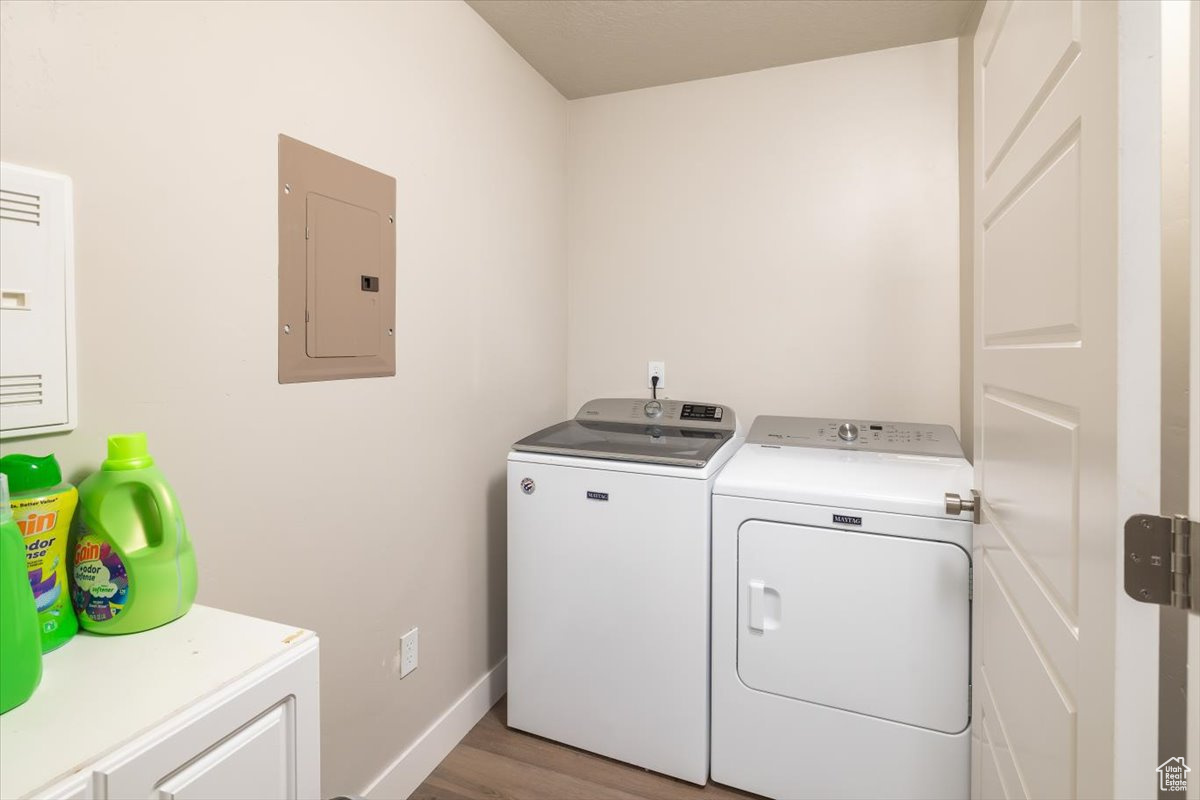 Washroom with washer and clothes dryer and light hardwood / wood-style floors