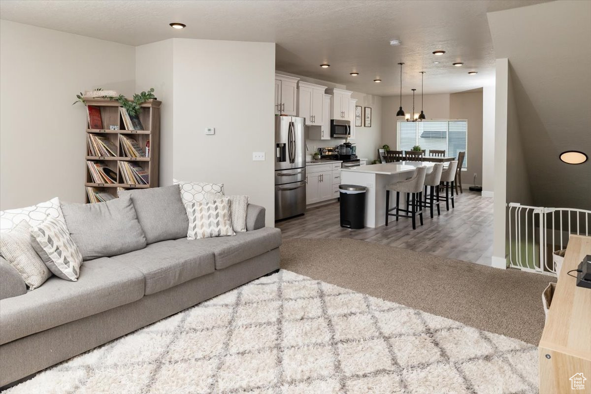 Carpeted living room featuring a notable chandelier