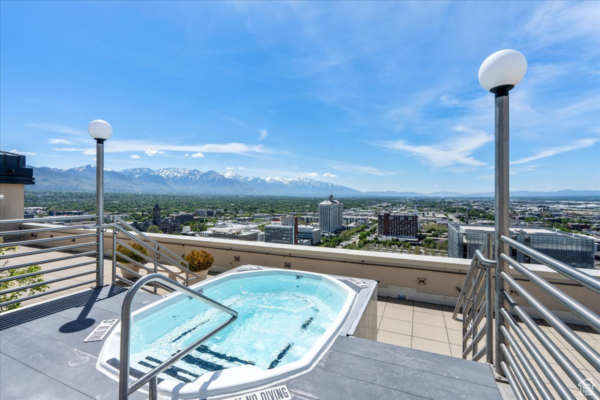 Exterior space with an in ground hot tub and a mountain view