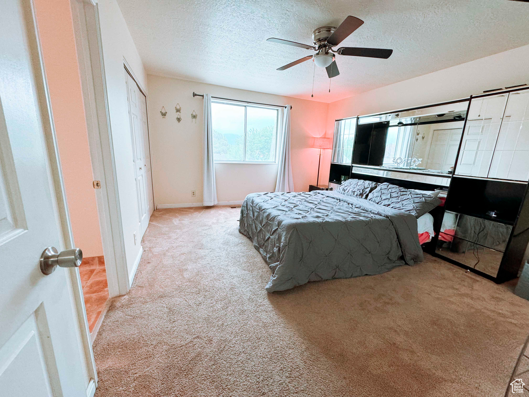 Bedroom featuring a textured ceiling, carpet, and ceiling fan