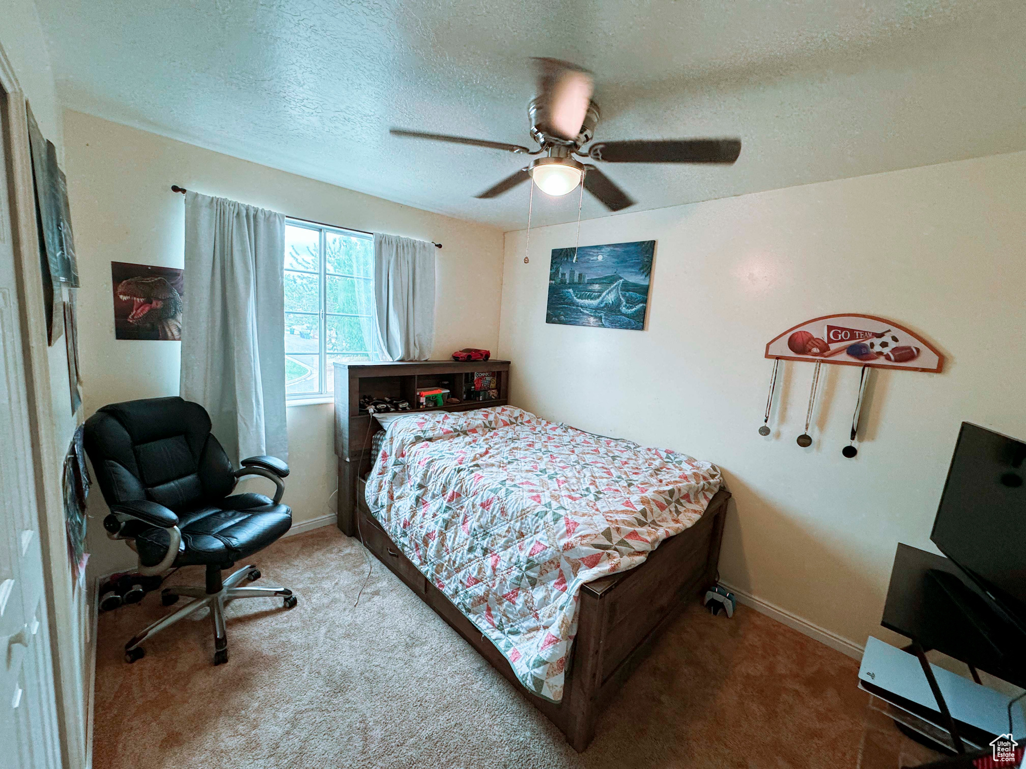 Bedroom featuring ceiling fan, carpet floors, and a textured ceiling