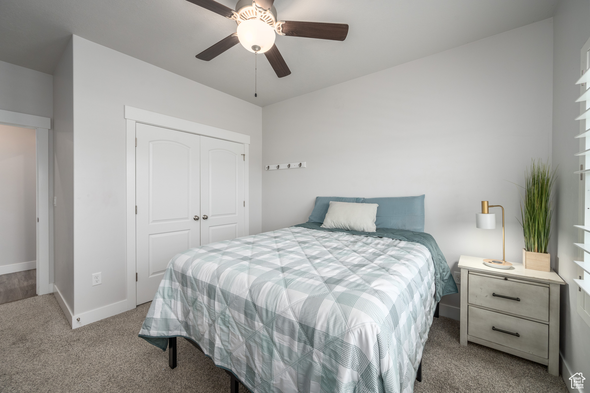 Bedroom featuring light carpet, a closet, and ceiling fan