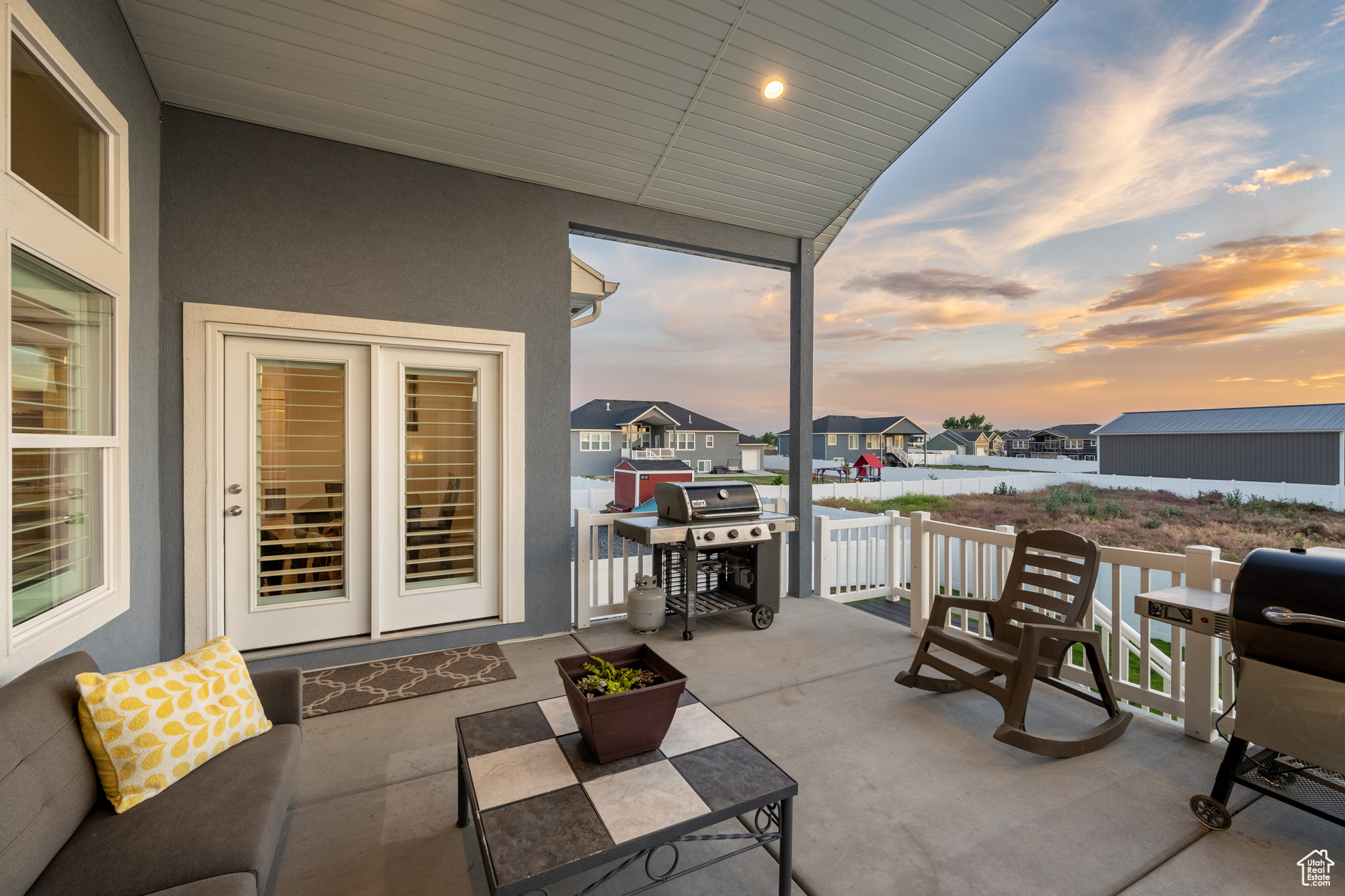 Patio terrace at dusk featuring a grill