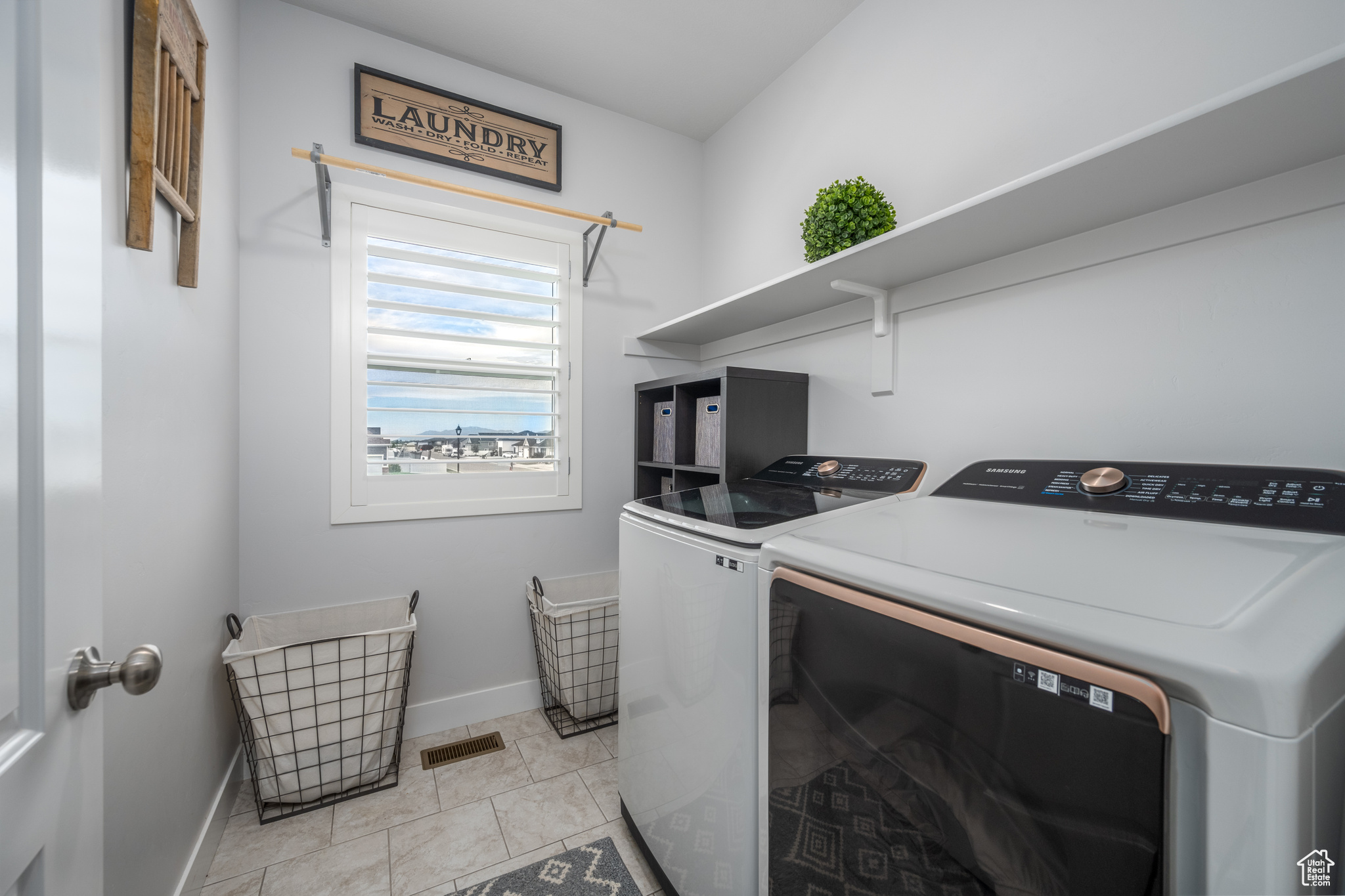 Laundry area featuring washer and dryer and light tile floors