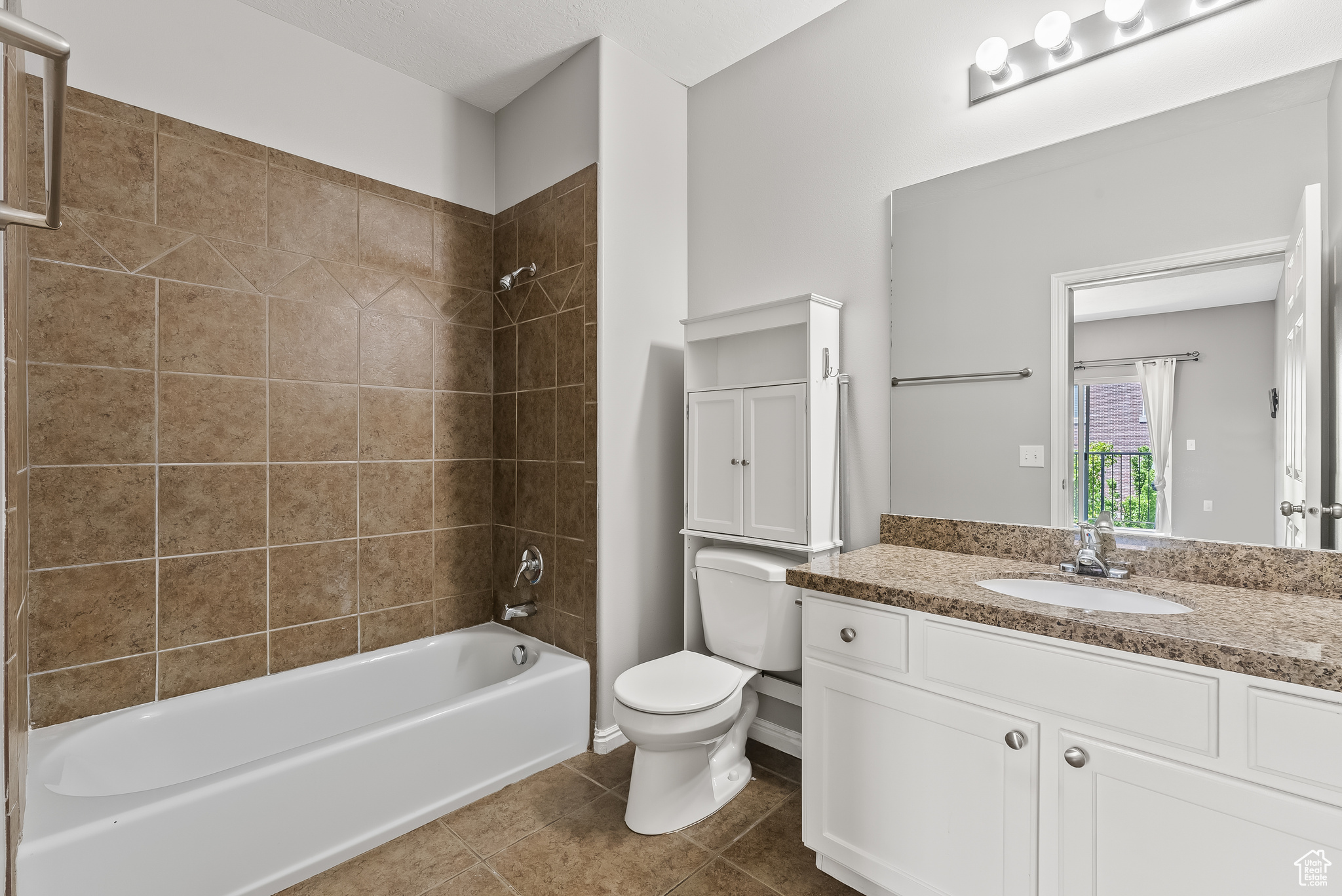 Private master bathroom with tile flooring, toilet, vanity, and tiled shower / bath,