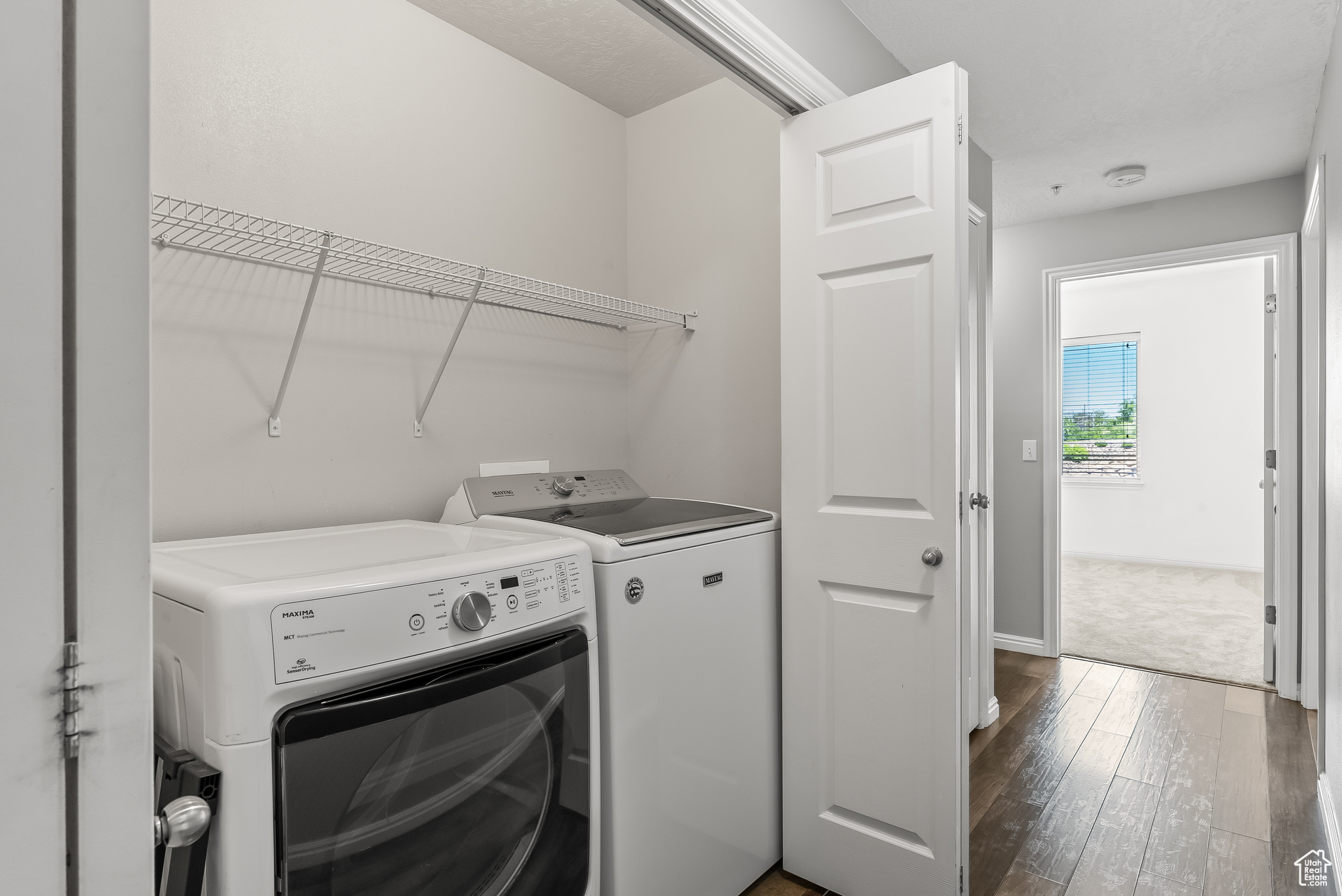 Washroom featuring hardwood / wood-style floors and newer washing machine and dryer