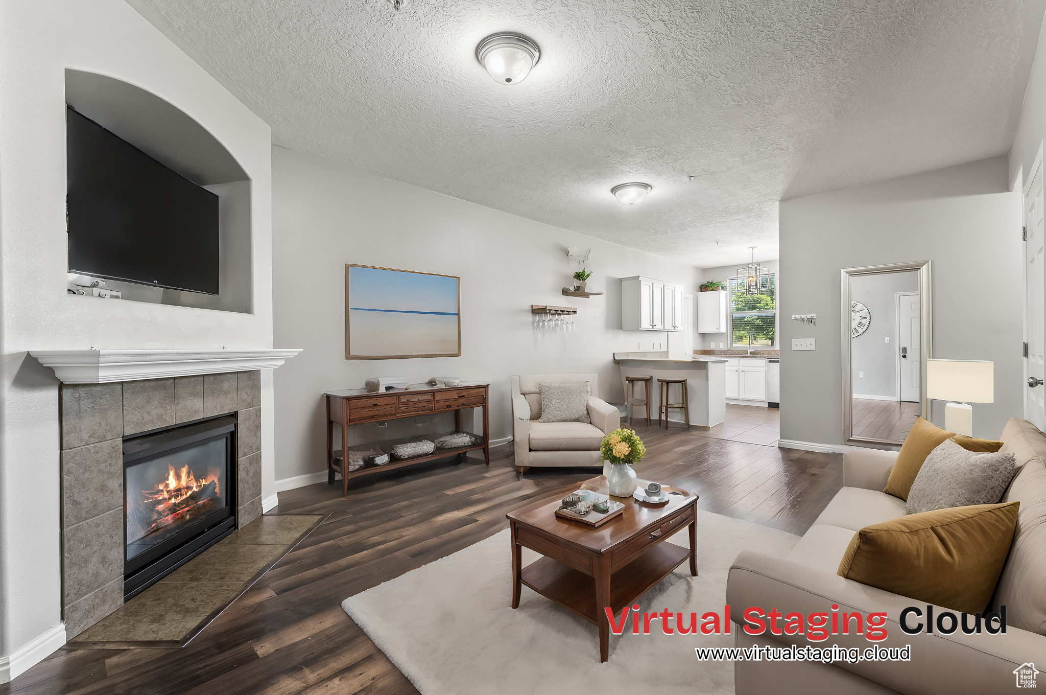 Living room featuring a textured ceiling, wood-type flooring, and a tile fireplace. Virtual Staging Options