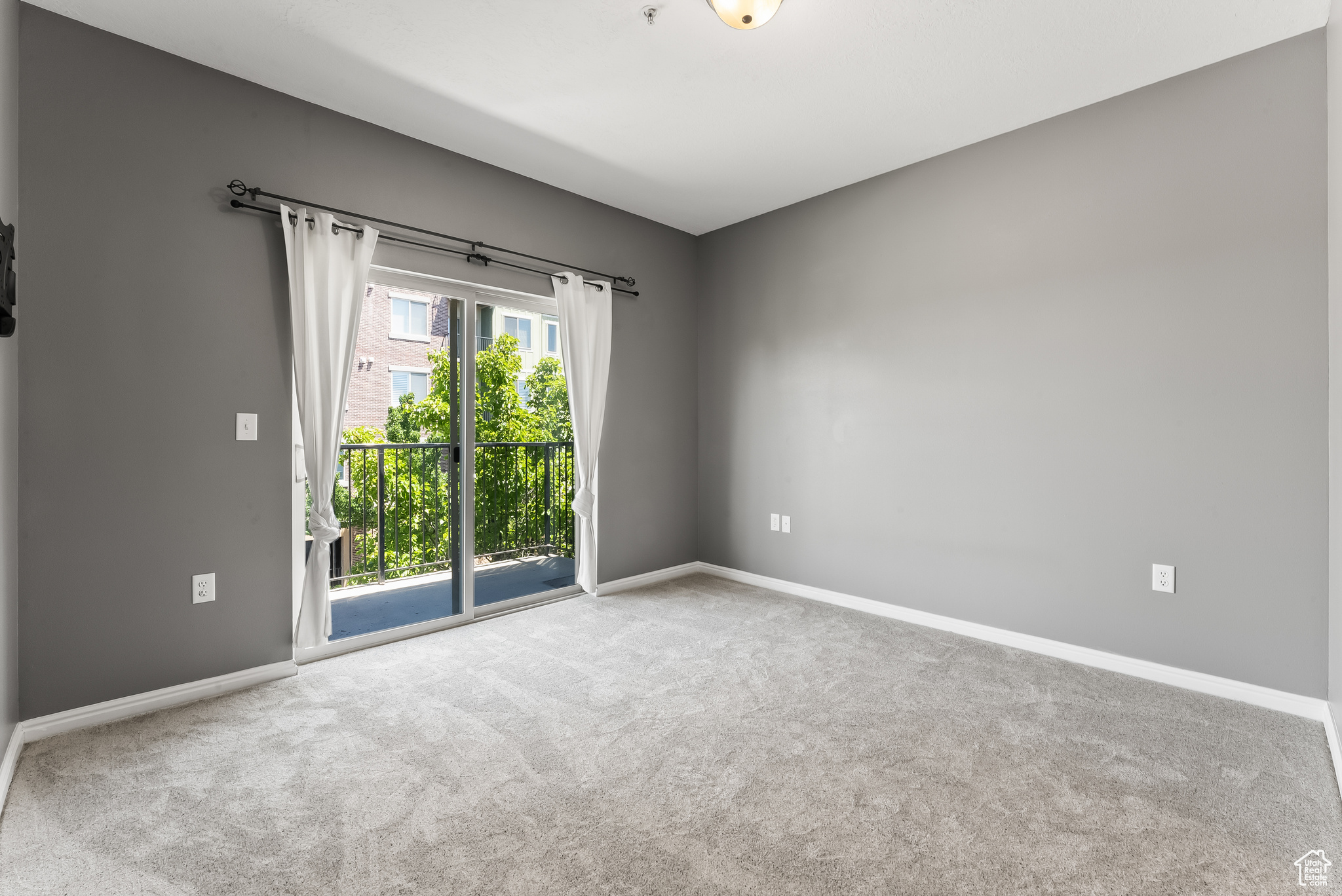 Master bedroom with new carpet and a sliding door that allows a lot of sunlight