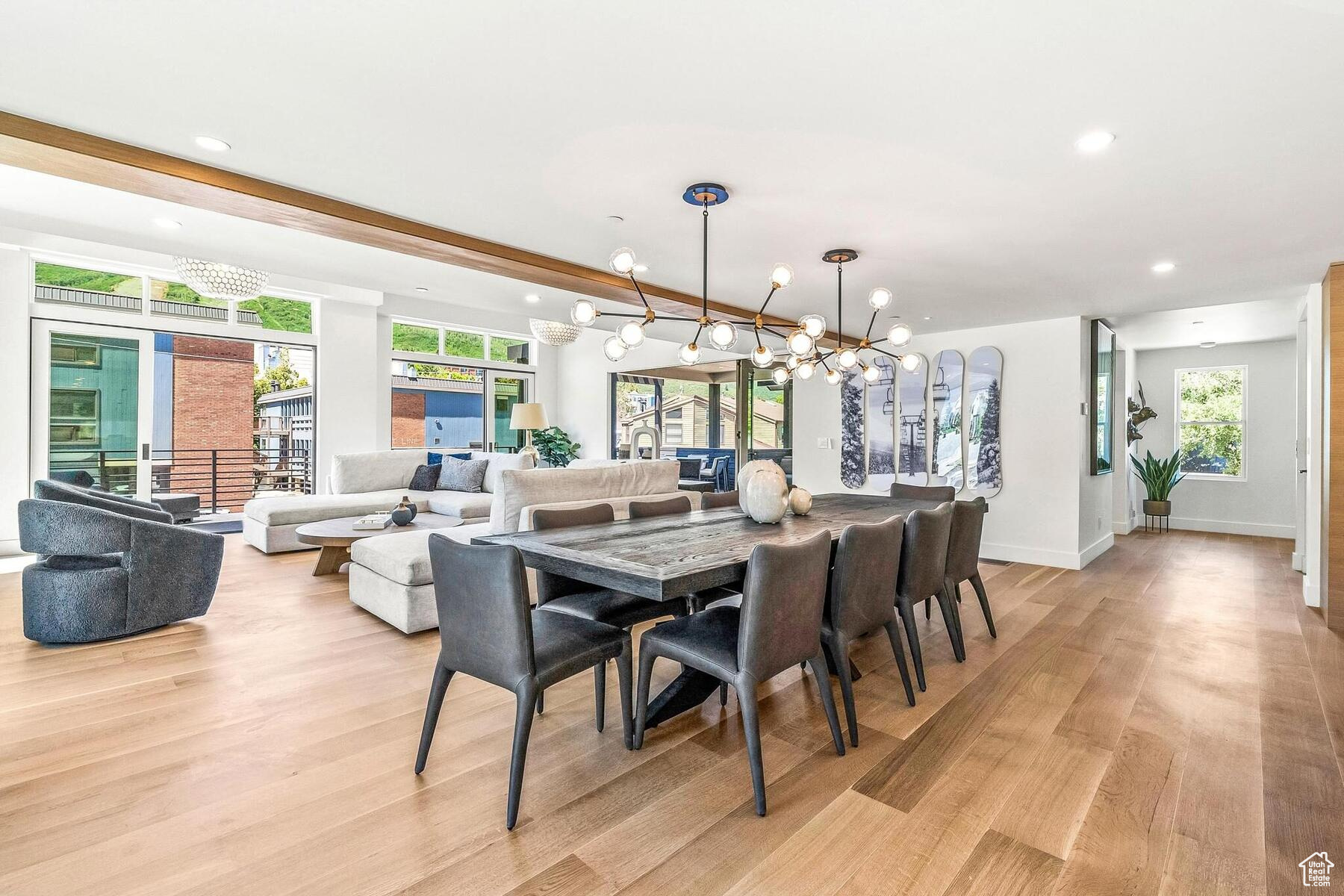 Dining space featuring plenty of natural light, light hardwood / wood-style floors, and an inviting chandelier