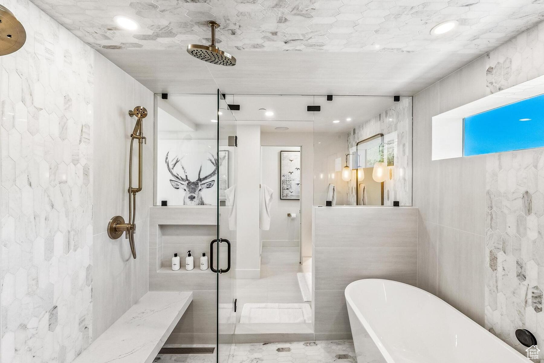 Bathroom featuring shower with separate bathtub, tile flooring, and tile walls