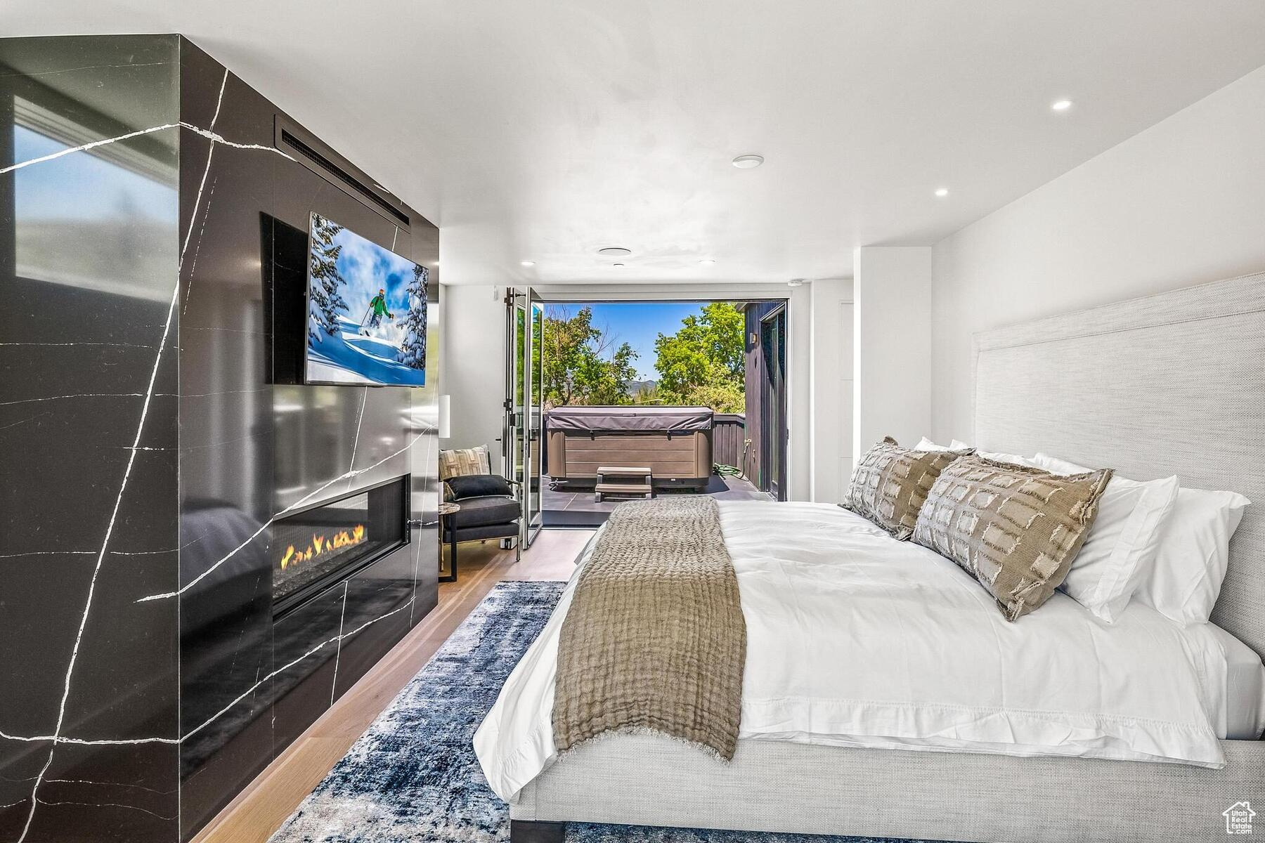 Bedroom with access to exterior and hardwood / wood-style flooring