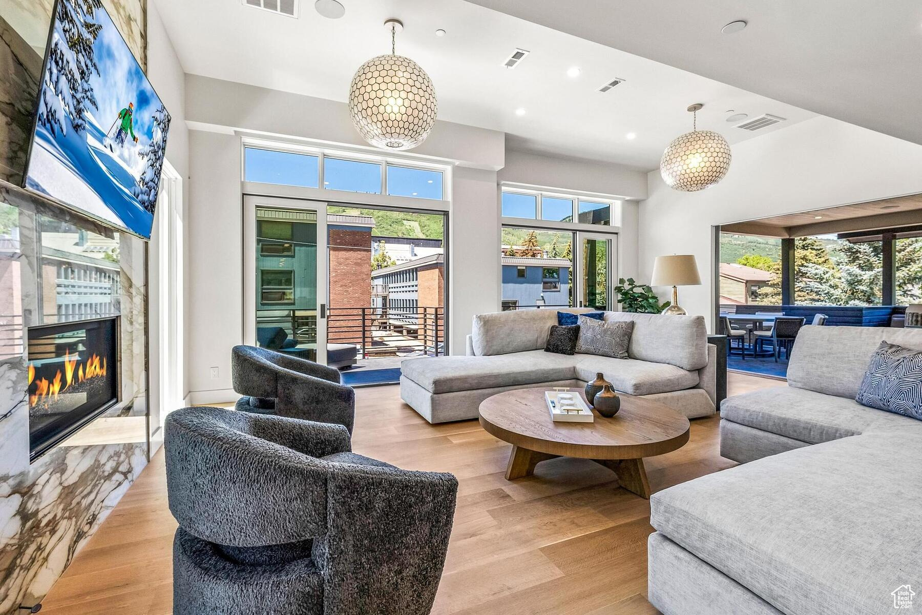 Living room featuring an inviting chandelier, plenty of natural light, and light hardwood / wood-style flooring