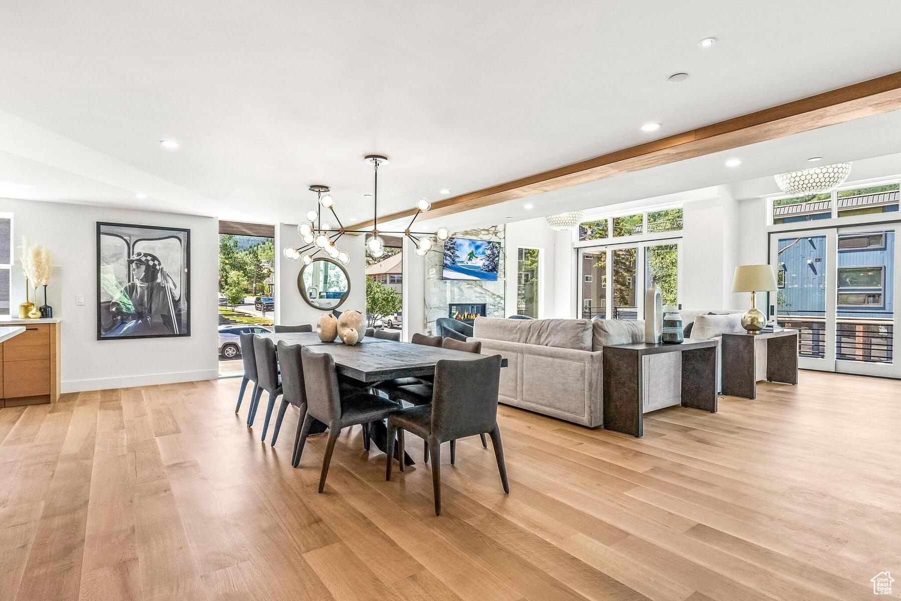 Dining area with a large fireplace, a chandelier, and light wood-type flooring