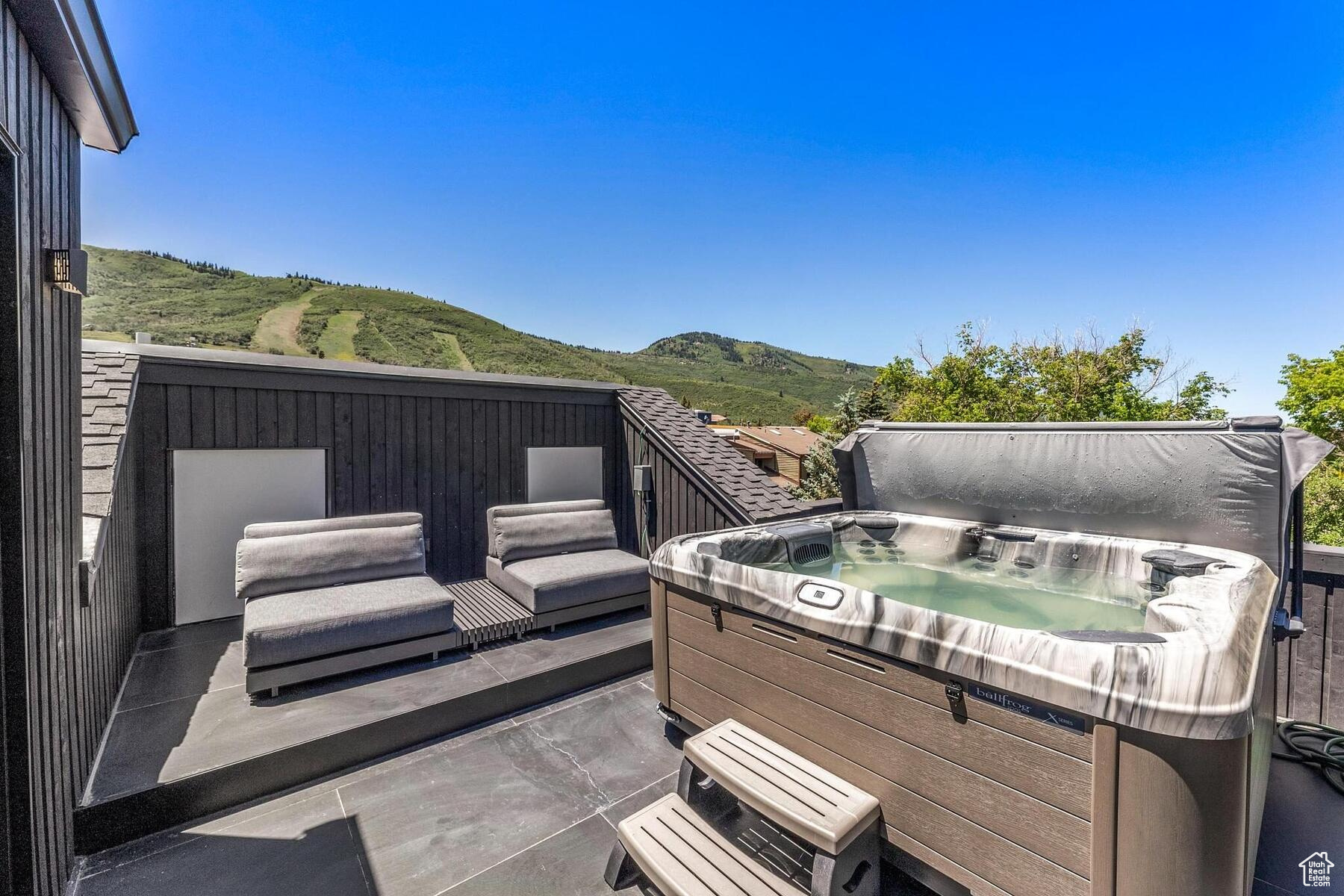 Wooden deck featuring a hot tub and a mountain view