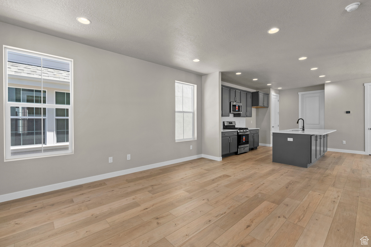 Interior space featuring sink, a textured ceiling, and light wood-type flooring