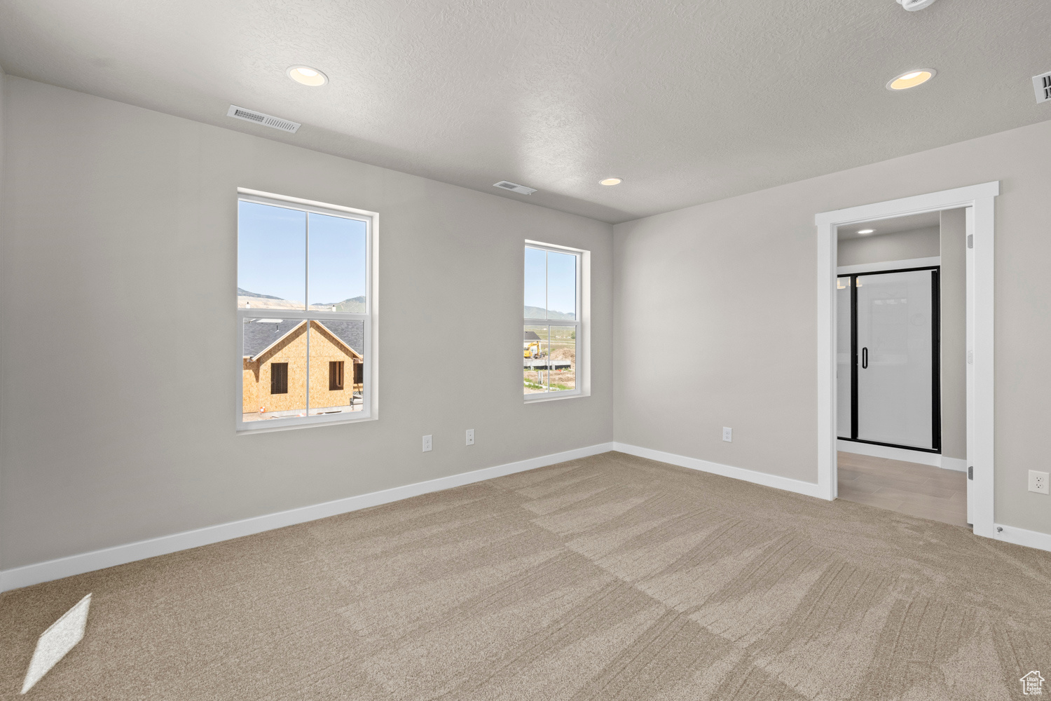 Spare room with light carpet and a textured ceiling