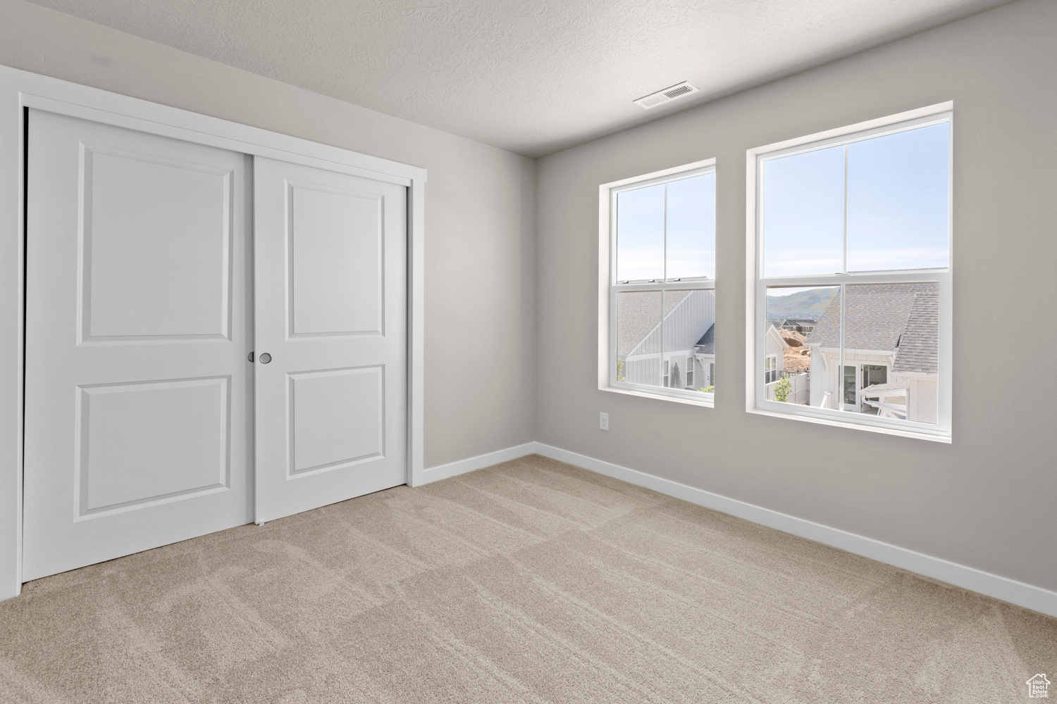 Spare room with light carpet and a textured ceiling