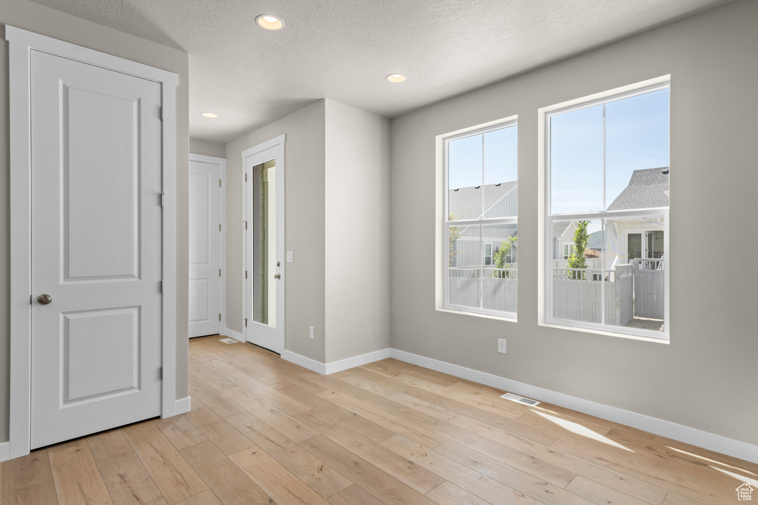 Empty room with light hardwood / wood-style flooring and a textured ceiling