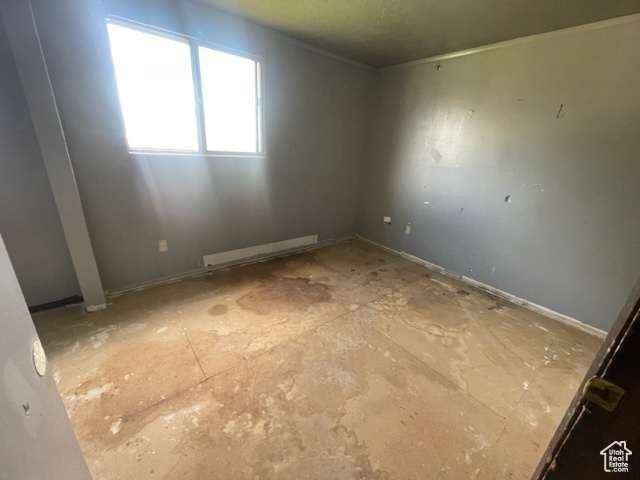 Unfurnished room with a baseboard heating unit